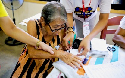 <p><strong>CIVIC DUTY.</strong> An elderly woman is assisted by poll personnel while casting her vote for the Barangay and Sangguniang Kabataan Elections at the Malagasang II Elementary School in Imus, Cavite on Oct. 30, 2023. The Department of Budget and Management has approved the creation of eight additional regional offices and 96 plantilla positions for the National Commission of Senior Citizens. <em>(PNA photo by Avito Dalan)</em></p>