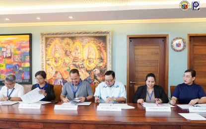 <p><strong>NEW SLAUGHTERHOUSE.</strong> Development Bank of the Philippines (DBP) Iloilo Branch Senior Assistant Vice President (SAVP) Rodel Bustillo and Iloilo City Mayor Jerry Treñas (third and fourth from left) sign an agreement for the PHP180-million loan to finance the upgrade of the city slaughterhouse on Monday (Nov. 7, 2023). The new slaughterhouse can accommodate up to 1,000 livestock heads a day once completed.<em> (Photo from Iloilo City government FB page)</em></p>
