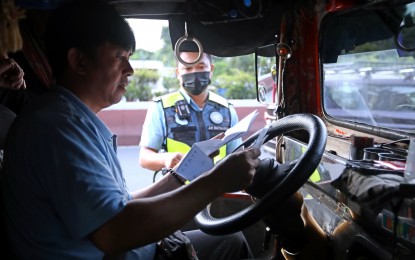 <p><strong>ENFORCEMENT.</strong> A jeepney driver presents documents to a Land Transportation Office enforcer during an anti-colorum operation along Aurora Boulevard in Quezon City on Nov. 9, 2023. Unregistered jeepneys, whether consolidated or not, will be apprehended after Jan. 31, 2024, an official of the Land Transportation Office warned on Wednesday (Jan. 17). <em>(PNA photo by Joey O. Razon)</em></p>
