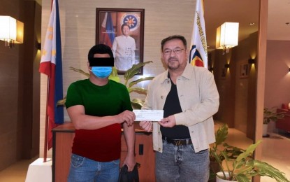 <p><strong>NEW MILLIONAIRE.</strong> PCSO general manager Melquiades Robles (right) hands over a check for PHP147.3 million to the winner of the Oct. 15 Super Lotto 6/49 jackpot, at the PCSO main office in Mandaluyong City on Oct. 17, 2023. The PCSO on Friday (Nov. 10, 2023) said the winner disclosed that his winning combination was a Lucky Pick or a system-generated selection from his previous bets. <em>(Photo courtesy of the PCSO)</em></p>