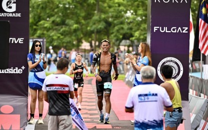 <p><strong>CHAMPION.</strong> Satar Salem of Lanao del Norte crosses the finish line during the Ironman 70.3 triathlon competition in Puerto Princesa, Palawan on Sunday (Nov. 12, 2023). He finished the 1.9km swim, 90km bike, and 21.1km race in four hours, 22 minutes and 25 seconds to pocket P60,000 in cash. <em>(Contributed photo)</em></p>