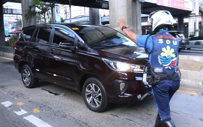 <p><strong>FEWER VIOLATORS</strong>. A Metropolitan Manila Development Authority enforcer stops a vehicle from using the EDSA bus lane on Nov. 13, 2023. The MMDA said on Monday (Dec. 4, 2023) that it has recently recorded a significant drop in busway violators. <em>(PNA photo by Joey Razon)</em></p>