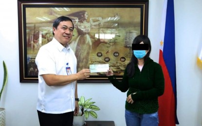 <p><strong>JACKPOT WINNER.</strong> Philippine Charity Sweepstakes Office (PCSO) Assistant General Manager Arnel Casas (left) hands over the check worth PHP34.5 million to the winner of the Oct. 12 Lotto 6/42 draw on Oct. 16, 2023. The PCSO on Monday (Nov. 13, 2023) said the winner used the ages and birthdates of her family members in her bets.<em> (Photo courtesy of the PCSO)</em></p>