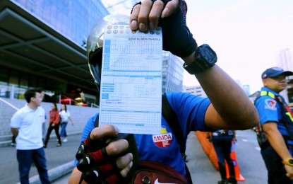 <p><strong>TRAFFIC TICKET.</strong> A Metropolitan Manila Development Authority (MMDA) personnel shows a copy of a traffic violation receipt issued to a motorist caught illegally driving through the EDSA bus lane northbound in Mandaluyong City on Monday (Nov. 13, 2023). Starting Nov. 13, fines and penalties were increased up to PHP30,000 and the driver’s license will also be suspended for repeated violations. <em>(PNA photo by Joey Razon)</em></p>