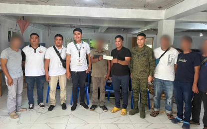 <p><strong>CASH AID</strong>. Sambayanan Association president Ka Edgar (5th from left) receives from Mayor Ariel de Jesus of San Luis, Aurora (5th from right) the PHP300,000 check as livelihood assistance from the Department of Social Welfare and Development on Monday (Nov. 13, 2023). The amount will be used by the Sambayanan Association whose members are composed of former rebels, for their piggery business that could help them start their new lives. <em>(Photo courtesy of the Army's 91IB)</em></p>
