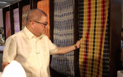 <p><strong>WORLD-CLASS.</strong> Secretary Francisco Tiu Laurel checks some of the local fabrics on display during the launch of the National Fibercrops Summit at the Department of Agriculture lobby in Diliman, Quezon City on Monday (Nov. 13, 2023). The summit aims to recognize fibercrops, such as abaca, cotton, piña, salago, and silk. <em>(Photo courtesy of DA)</em></p>