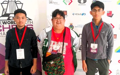 <p><strong>FIRST-ROUND WINNERS.</strong> FIDE Masters Mark Jay Bacojo (left) and Christian Gian Karlo Arca (right) pose for a photo after their first-round victories at the FIDE World Youth Championships in Montesilvano, Italy on Nov. 13, 2023. Between them is Team Philippines head of delegation Arena Grandmaster Almario Marlon Quiroz Bernardino Jr., who also serves as coach. <em>(Contributed photo)</em></p>