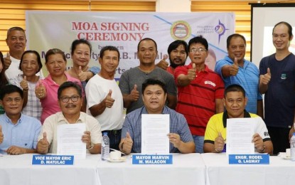 <p><strong>AGREEMENT</strong>. E.B. Magalona Vice Mayor Eric Matulac and Mayor Marvin Malacon, with Rodel Lagmay (seated, from left), acting port manager of the Philippine Ports Authority - Port Management Office Negros Occidental, show the signed memorandum of agreement for the development of the Saravia Municipal Port in rites held at the town’s Asenso Hall Friday afternoon (Nov. 17, 2023). The soon-to-be-constructed municipal port is expected to bring in more economic opportunities, Malacon said in a statement on Saturday (Nov. 18). <em>(Photo courtesy of E.B. Magalona-PIO)</em></p>