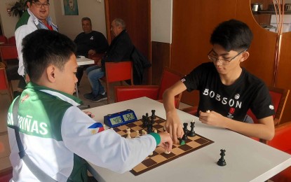 <p><strong>PRACTICE SESSION.</strong> FIDE Masters Mark Jay Bacojo (left) plays a blitz game with Christian Gian Karlo Arca during the rest day of the World Youth Chess Championships in Montesilvano, Italy on Nov. 19, 2023. Looking on is Arena Grandmaster Almario Marlon Quiroz Bernardino Jr., one of the coaches of Team Philippines. <em>(Contributed photo)</em></p>