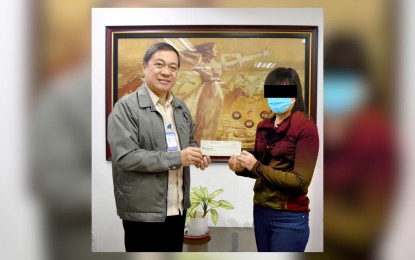 <p><strong>WINNER.</strong> Philippine Charity Sweepstakes Office Assistant General Manager Arnel Casas (left) hands over the check worth PHP15 million to one of two winners of the PHP30-million Mega Lotto 6/45 jackpot, drawn Oct. 25, 2023, at the agency's main office in Mandaluyong City on Nov. 9. The PCSO on Tuesday (Nov. 21) said the other winner of the jackpot is from Sultan Kudarat.<em> (Photo courtesy of PCSO)</em></p>