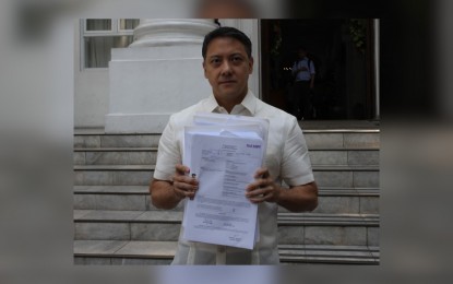 <p><strong>CHARGED. </strong>BIR Commissioner Romeo Lumagui shows news reporters a copy of the complaint filed by his agency against 69 firms and indivduals. Lumagui said the charges involve the illicit trade of "ghost receipts" by companies through unscrupulous accountants and lawyers. <em>(PNA photo by Ben Pulta)</em>  </p>