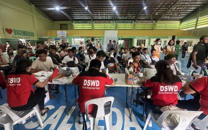<p><strong>PAYOUT.</strong> In this file photo, personnel of the Department of Social Welfare and Development (DSWD)-5 (Bicol) distribute financial assistance to Mayon unrest-affected families in Camalig, Albay as part of the early recovery aid provided by the agency through the Emergency Cash Transfer program. <em>(Photo courtesy of DSWD-Bicol)</em></p>