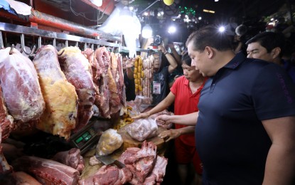 <p><strong>PRICE CHECK.</strong>  House Speaker Martin Romualdez checks on the meat section of the Farmers Market in Quezon City on Monday (Nov. 27, 2023).  Romualdez made the rounds with Deputy Majority Leader Erwin Tulfo (partly hidden) to ensure that prices of basic commodities are within the limits of suggested retail prices as the holidays are approaching.  <em>(PNA photo)</em></p>
