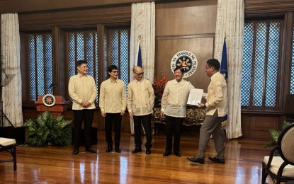 <p><strong>CLIMATE ADAPTATION.</strong> Borongan City Mayor Jose Ivan Dayan Agda (right) receives the People's Survival Fund (PSF) from President Ferdinand R. Marcos Jr. during the ceremonial turnover of a PHP118.86 million grant, at the President's Hall of Malacañan Palace in Manila on Wednesday (Nov. 29, 2023). In a statement, Agda pledged to use the fund to address the city’s flooding problem. <em>(Photo courtesy of Borongan City government)</em></p>