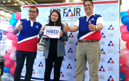 <p><strong>HIRED ON THE SPOT</strong>. Shaira Carlon (center), 28, poses with Department of Labor and Employment (DOLE) – Cordillera Assistant Director Emerito Narag (left) and Director Nathan Lacambra after she was hired on the spot within 30 minutes after the opening of the job fair at the Porta Vaga Mall in Baguio City on Friday (Dec. 1, 2023). About 3,523 job vacancies were up for grabs during the event, which was participated in by 30 companies as part of DOLE’s 90th anniversary celebration. <em>(PNA photo by Liza T. Agoot)</em></p>