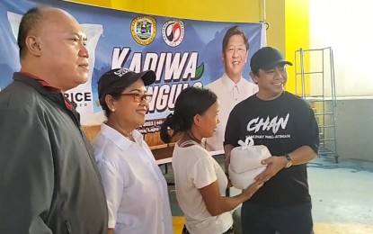 <p><strong>MOBILE KADIWA.</strong> Mayor Junard Chan (right) hands two packs of rice to a resident of Olango Island, the first to benefit from the PHP20 per kilo Kadiwa ng Pangulo rice in Lapu-Lapu City, Cebu province on Friday (Dec. 1, 2023). Chan said the city government will soon roll out the Mobile Kadiwa ng Pangulo to bring PHP20 per kilo NFA rice right at the doorsteps of residents. <em>(Contributed photo)</em></p>