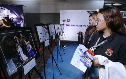<p><strong>CAMPUS CARAVAN</strong>. Lyceum of the Philippines University students look at the photos taken by Philippine News Agency photographers during the Presidential Communications Office CommUNITY Campus Caravan in Intramuros, Manila on Dec. 5, 2023. The campus caravan features exhibition booths, media information literacy workshops, creative contests and competitions, panel discussions and internship information booth. <em>(PNA file photo by Joey O. Razon)</em></p>