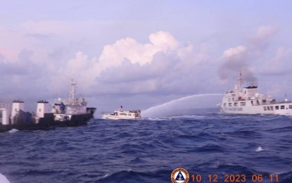 <p><strong>BULLY.</strong> An imposing China Coast Guard vessel (right) trains its water cannon on a Philippine ship in Ayungin Shoal on Sunday (Dec. 10, 2023). Four Philippine ships on regular rotation and resupply mission to the BRP Sierra Made were harassed yet again by the CCG, just a day after three Bureau of Fisheries and Aquatic Resources vessels providing humanitarian support to Filipino fisherfolk off Bajo de Masinloc (Scarborough Shoal) were also water cannoned at least eight times. <em>(Photo courtesy of PCG)</em></p>