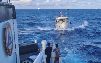 <p><strong>LIFELINE</strong>. A Philippine Coast Guard vessel throws a cable to one of the civilian resupply vessels damaged during the run-in with Chinese vessels in Ayungin Shoal on Sunday morning (Dec. 10, 2023). Only the civilian ship Unaizah Mae 1 reached the BRP Sierra Madre to deliver supplies and other provisions. <em>(Photo courtesy of PCG)</em></p>