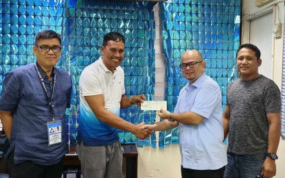 <p><strong>VULCANIZING BUSINESS</strong>. Roque Camarillo (second from left), president of North Dalaguete Tricycle Operators and Drivers Association, receives from DOLE-7 OIC Assistant Regional Director Emmanuel Ferrer a check worth PHP1 million on Tuesday (Dec. 12, 2023). The amount will be used to bankroll the association's new business --a vulcanizing and motor shop that will be owned by the group's 54 members in Dalaguete, Cebu. <em>(Photo courtesy of DOLE-7)</em></p>