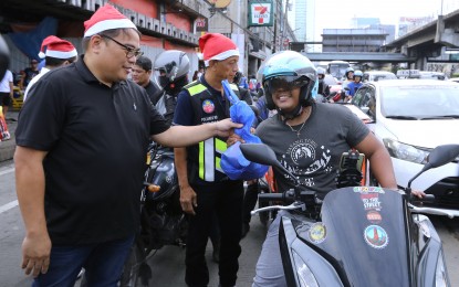 <p><strong>CHRISTMAS GIFT</strong>. Metropolitan Manila Development Authority acting chair Romando Artes leads Christmas gift-giving to ride-hailing riders along Epifanio de los Santos Avenue (EDSA) in Cubao, Quezon City on Tuesday (Dec. 19, 2023). Artes said the activity is part of the agency's "ticket or treat" project which aims to give back to disciplined motorcycle riders who follow traffic laws and regulations.<em> (PNA photo by Joey O. Razon)</em></p>