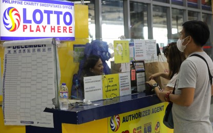 <p><strong>HIGHER REVENUES. </strong>A commuter place his bets at a lotto outlet inside the Parañaque Integrated Terminal Exchange in this Dec. 19, 2023 photo. The Philippine Charity Sweepstakes Office (PCSO) recorded PHP61.45 billion in gaming revenues in 2023, a 7 percent hike from PHP57.467 billion in 2022. (PNA file photo by Yancy Lim)</p>