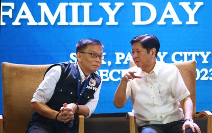 <p><strong>REAPPOINTED.</strong> Department of Migrant Workers (DMW) Secretary Hans Leo Cacdac (left) listens to President Ferdinand R. Marcos Jr. during the OFW Family Day celebration at the SMX Convention Center in Pasay City on Dec. 20, 2023. Cacdac was reappointed by the President as DMW ad interim secretary after the Commission on Appointments deferred his confirmation due to lack of time. <em>(PNA photo by Joan Bondoc)</em></p>