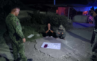 <p><strong>COLLARED.</strong> Two women suspected of peddling shabu are seen as police officers conduct an accounting of a prohibited substance allegedly seized from them during an anti-drug operation on Christmas Day (Dec. 25, 2023) in Datu Odin Sinsuat, Maguindanao Norte. Lt. Colonel Ismael Madin (standing left), Datu Odin town police chief, said the two had been under surveillance for two weeks before their arrest. <em>(Contributed photo)</em></p>