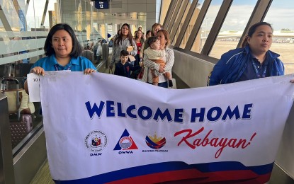 <p><strong>WELCOME BACK.</strong> Nine overseas Filipino workers and five children arrive at the NAIA Terminal 1 on Thursday (Dec. 28, 2023) from Lebanon via Philippine Airlines flight PR685. The Department of Migrant Workers welcomed the group and assured them of assistance from the government. <em>(Photo courtesy of DMW)</em></p>