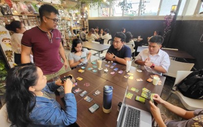 <p><strong>CHILL</strong>. Customers of a coffee shop along Session Road in Baguio City play board games, which are additional offerings of the cafe. Shop owner Guil Ocampo said his training under the Department of Trade and Industry’s “Kapatid Mentor Me” program is a big help in his busines' operation. <em>(Photo courtesy of Ginto Cafe)</em></p>