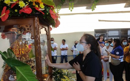 <p><strong>DEVOTION TO THE STO. NIÑO.</strong> A devotee prays before the pilgrim image of the Señor Sto. Niño during its visit to the Cebu South Medical Center in San Isidro, Talisay City on Thursday (Jan. 4, 2024). The visitation of the holy image to hospitals and jails is part of the Cebuanos’ pre-fiesta tradition to allow devotees living in remote areas to pray to the Holy Child Jesus before the Sinulog festival on Jan. 11-26. <em>(Photo courtesy of Basilica Minore del Sto. Niño)</em></p>