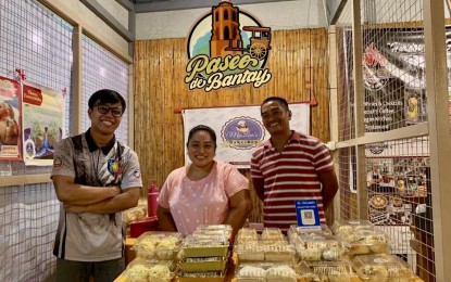 <p><strong>BAKE FOR LOVE</strong>. Bakeshop owners Mylene Galano (middle) and his husband, Alladin (right), from Ilocos Norte share a smile in one of their partner shop, Paseo de Bantay in Bantay, Ilocos Sur. The Galano couple is among the exhibitors in the ongoing trade fair that will run until the end of this month at the Mariano Marcos State University in Batac City. <em>(Photo courtesy of Mylan’s Bakeshop)</em></p>