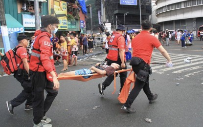 <p><strong>MEDICAL AID</strong>. Philippine Red Cross volunteers carry a male devotee of the Black Nazarene on a stretcher at the corner of General Solano and Palanca Streets in Quiapo, Manila on Tuesday (Jan. 9, 2024). The PRC said a total of 706 devotees received medical help. <em>(PNA photo by Robert Alfiler)</em></p>