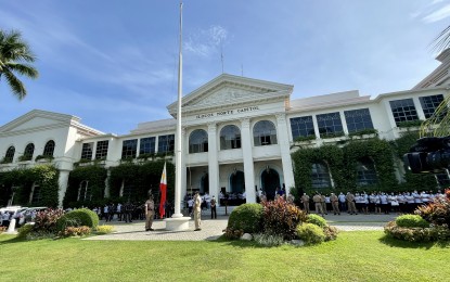 <p><strong>GOING SOLAR</strong>. Employees of the Ilocos Norte Capitol attend a flag-raising ceremony in this undated photo. Solar panels are currently installed in this heritage building to cut electricity cost. <em>(File photo by Leilanie Adriano)</em></p>