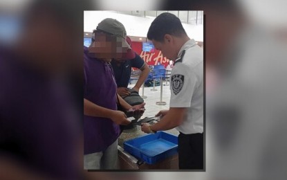 <p><strong>SWIFT ACTION. </strong>Security Screening Officer Joseph Mateo (right) immediately requested a CCTV review after seeing a wallet left behind in the initial security checkpoint at the  Iloilo International Airport on Jan. 13, 2024.  The passenger (face blurred as he apparently requested anonymity) was able to get his wallet containing PHP60,000 on the same day. (<em>Photo courtesy of Kim Marquez</em>) </p>