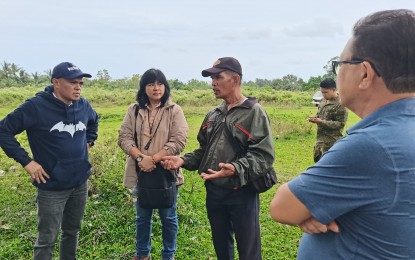 <p><strong>LAND DISTRIBUTION.</strong> Manuel Galon Jr., (left) Provincial Agrarian Reform Officer 1 of the Department of Agrarian Reform in Negros Oriental, talks to stakeholders during a site inspection in this undated photo in Basay, Negros Oriental in this undated photo. The DAR has already issued a Notice to Proceed in the distribution of land titles to former New People's Army rebels who will benefit from the housing project. <em>(PNA file photo by Mary Judaline Flores Partlow)</em></p>