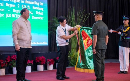 <p><strong>AWARD.</strong> President Ferdinand R. Marcos Jr., in the presence of Defense Secretary Gilbert Teodoro (left), bestows the campaign streamer award to the Philippine Army’s 303rd Infantry Brigade headed by commander Brig. Gen. Orlando Edralin (right), for dismantling guerrilla fronts in Negros Island and significantly contributing to the Armed Forces of the Philippines’ overall victory against communist-terrorist groups. The awarding ceremony was held during the AFP Year-End 2023 Command Conference at Camp Aguinaldo in Quezon City on Monday (Jan. 15, 2024). (<em>Photo courtesy of 3rd Infantry Division, Philippine Army</em>)</p>