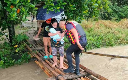 <p><strong>BAD WEATHER.</strong> A member of the local rescue team assists in the evacuation of residents in Lasang, Davao City on Tuesday (Jan. 16, 2024). The NDRRMC on Wednesday (Jan. 17) said some 552 families or 2,212 persons have so far been affected by bad weather caused by the shear line in the Davao Region. <em>(Photo courtesy of Luv Lasang)</em></p>