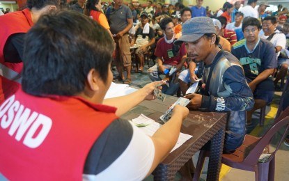 <p><strong>CRISIS AID</strong>. Social welfare personnel distribute cash assistance to a person in crisis situation in this file photo. Department of Social Welfare and Development regional director Shalaine Marie Lucero on Tuesday (Jan. 30, 2024) said the agency released a total of PHP2.4 billion under the Assistance to Individuals in Crisis Situations (AICS) program in 2023. <em>(Photo courtesy of DSWD-7)</em></p>