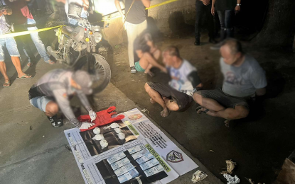 <p><strong>WEEKEND DRUG HAUL</strong>. A plainclothes police officer inventories shabu seized from the handcuffed suspects (seated, right) in the aftermath of a buy-bust in Lumban, Laguna on Saturday (Feb. 3, 2024). Also seen is the marked money used by undercover officers. <em>(Photo courtesy of Police Regional Office 4A)</em></p>