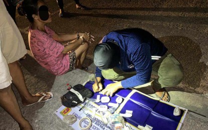 <p><strong>DRUG HAUL</strong>. Drug enforcement agents of Bacolod City Police Office arrest Ma. Faith Salaver Equibal (seated, left) in a sting operation in Purok Narra Baybay, Barangay 8 Saturday night (Feb. 10, 2024). The suspect yielded 312 grams of shabu valued at PHP2.121 million. <em>(Photo courtesy of Bacolod City Police-City Drug Enforcement Unit)</em></p>