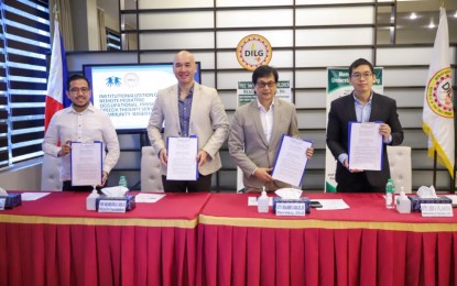 <p><strong>EMPOWERING DISABLED KIDS.</strong> DILG Secretary Benjamin Abalos Jr. (2nd from right) and Rehabilitation and Empowerment of Adults and Children with Handicap Foundation Inc. (REACH Foundation) president Prof. Abelardo Apollo David Jr. (2nd from left) show a copy of the signed memorandum of understanding (MOU) in Camp Crame, Quezon City on Feb. 8, 2024. Under the pact, CWD beneficiaries would have access to free occupational, physical and speech therapy services through teletherapy.<em> (Photo courtesy of DILG)</em></p>