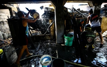 <p><strong>DISASTER.</strong> Fire burns down a residential area in Sta. Mesa, Manila on Feb. 21, 2024. The Department of Energy advises house owners to check on their electrical connections when they leave during the Holy Week. <em>(PNA photo by Joan Bondoc)</em></p>