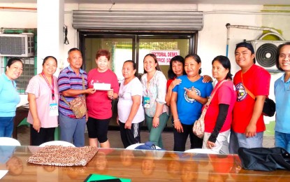 <p><strong>LIVELIHOOD ASSISTANCE.</strong> Members of the Dumaguete Public Market Fruits and Vegetables Vendors Association in Dumaguete City, Negros Oriental receive a check for PHP500,000 from a representative of the Department of Labor and Employment (DOLE) on Wednesday (Mar. 6, 2024). The association is composed of 87 members, mostly women. <em>(Photo courtesy of DOLE-7)</em></p>