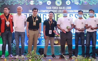 <p><strong>FINANCIAL SUPPORT.</strong> Interior Secretary Benjamin Abalos Jr. (3rd from left) and Surigao del Sur Gov. Alexander Pimentel (2nd from left) lead the distribution of PHP5.3 million financial aid to 66 former rebels in Tandag City on Wednesday (March 6, 2024). The former rebels also received PHP660,000 worth of assistance from the different government line agencies.<em> (Photo courtesy of Gov. Ayec Pimentel)</em></p>