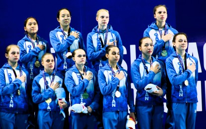<p><strong>ARTISTIC CHAMPS</strong>. Kazakhstan's Dayana Jamanchalova (front row, extreme right) and her teammates sing their national anthem during the awarding ceremony of the 11th Asian Age Group Championships at the New Clark City Aquatic Center in Capas, Tarlac on March 6, 2024. She collected four gold medals to lead her team won the overall artistic swimming competition. <em>(AAGC photo)</em></p>