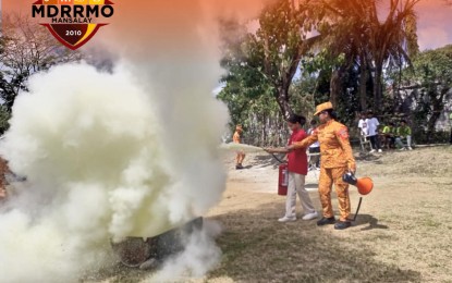 <p><strong>WILDFIRE FIGHT</strong>. A female firefighter in Mansalay town, Oriental Mindoro instructs a woman on the use of a fire extinguisher on Thursday (March 7, 2024). The town has seen a surge of wildfires due to the drought. <em>(Photo courtesy of Mansalay MDRRMO)</em></p>
