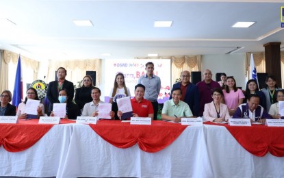 <p><strong>‘TARA BASA!’ GOES TO CEBU.</strong> Social Welfare Secretary Rex Gatchalian (center) and key partners sign a memorandum of agreement for the implementation of the “Tara Basa!” tutoring program in Cebu City, in a ceremony held at the Cebu City Hall on Friday (March 8, 2024). The program will benefit struggling and non-reading elementary students, their parents, and college students from state colleges and universities. <em>(Photo courtesy of DSWD)</em></p>