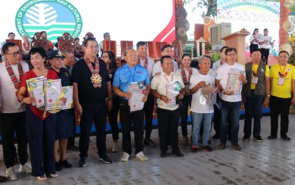 <p><strong>FREE LAND TITLES.</strong> Ilonggos receive their land titles from House Speaker Martin Romualdez (4th from left) in Guimbal, Iloilo in December 2023. The Department of Environment and Natural Resources reported on Monday (March 11, 2024) that it released 2,204 free residential and agricultural patents covering 882.097 hectares in Western Visayas in 2023, exceeding the 1,600 target patents in the region. <em>(Photo courtesy of DENR 6)</em></p>
