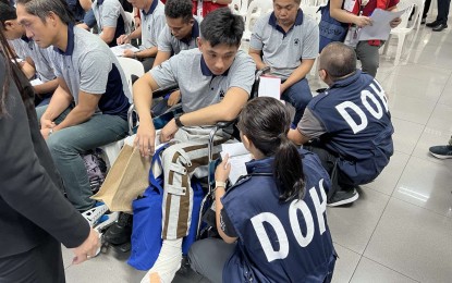 <p><strong>SURVIVORS ARRIVAL</strong>. Personnel of the Department of Health provide medical attention to the survivors of the Houthi missile attack upon their arrival at the NAIA Terminal 3 on Tuesday evening (March 12, 2024). The attack on the M/V True Confidence killed three -- two Filipinos and one Vietnamese.<em> (Photo courtesy of DMW)</em></p>
